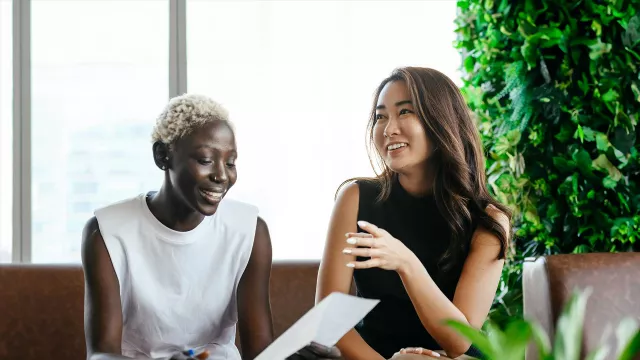 Two office employees smiling while talking