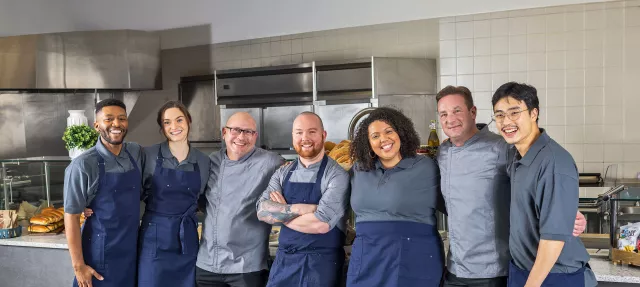 Chefs and cooks smiling in kitchen