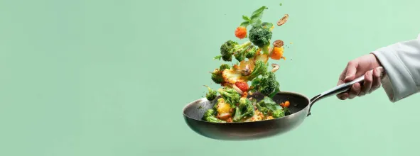 Vegetables being tossed in saute pan